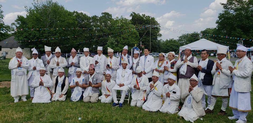 Members of the Kirat community gathered outdoors in traditional attire